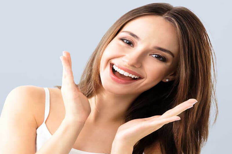 Picture of a smiling woman, happy with her dental bridge.