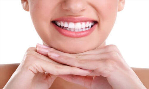 Close-up picture of a smiling woman with perfect teeth showing her happiness with the dental crowns she received at Premier Holistic Dental in Costa Rica.