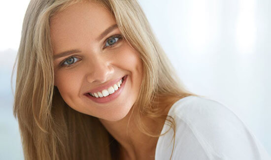 Picture of a smiling woman, showing her happiness with the all-on-eight dental treatment she had in Costa Rica.