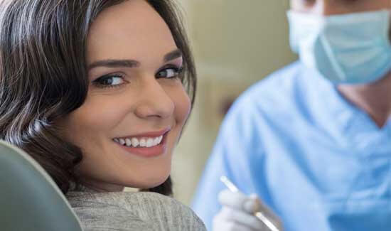 Picture of a woman, smiling at the camera, illustrating her happiness with the full mouth makeover she had in Costa Rica.