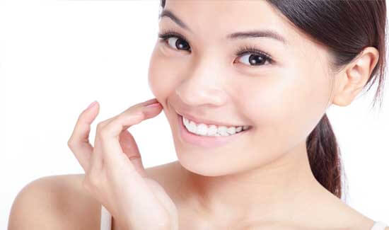 Picture of a woman, smiling at the camera, illustrating her happiness with the Holistic Dentistry she had in Costa Rica.