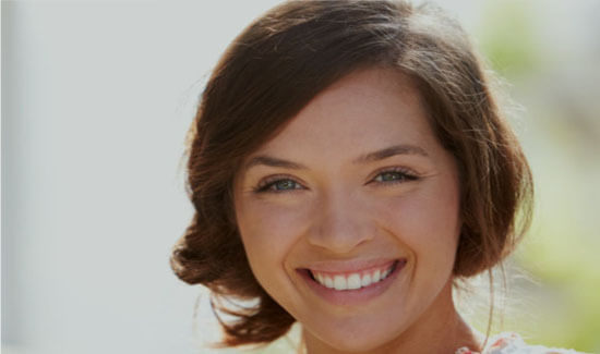 Picture of a smiling woman, showing her happiness with the implant-supported bridges she had in Costa Rica.