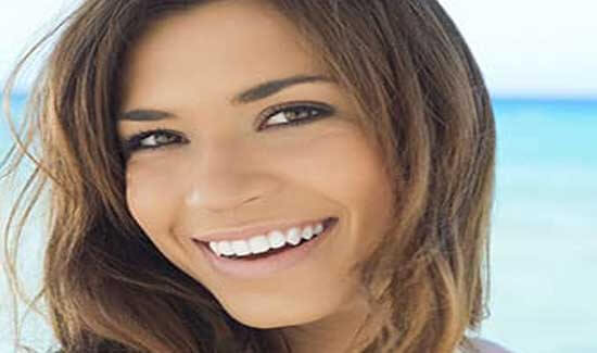 Picture of a woman, smiling at the camera, illustrating her happiness with the mercury-free/fluoride-free fillings she had in Costa Rica.