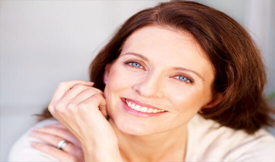 Picture of a woman, smiling at the camera, illustrating her happiness with the periodontics procedure she had in Costa Rica.