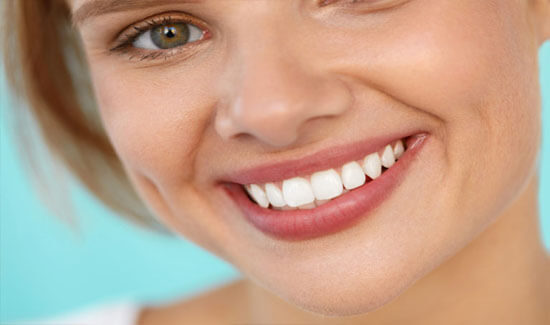 Picture of a woman, smiling at the camera, illustrating her happiness with the root canals treatment she had in Costa Rica.