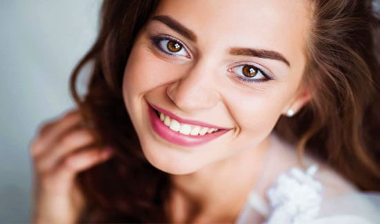 Picture of a woman, smiling at the camera, illustrating her happiness with the dental whitening she had in Costa Rica.