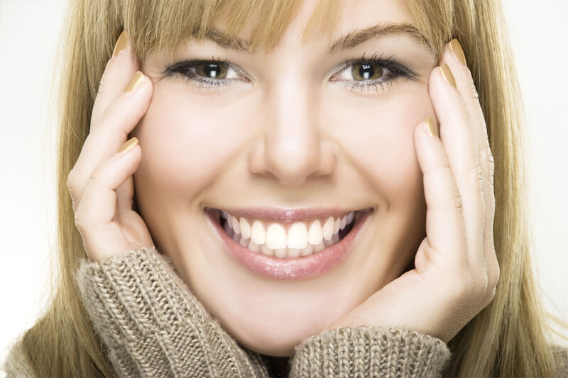 Picture of a smiling woman, happy with implant-supported bridge.