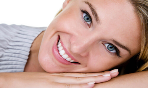 Close-up picture of a smiling woman showing her perfect teeth and happy with the oral surgery procedure she had done at Premier Holistic Dental in San Jose, Costa Rica.