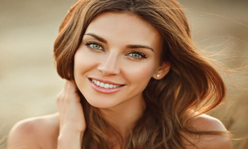 Close-up picture of a smiling young woman with perfect teeth happy with her Holistic safe mercury removal at Premier Holistic Dental in Costa Rica.