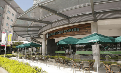 Picture of a 5 story office building in Costa Rica.  A Starbucks coffee store is shown in the center of the picture.